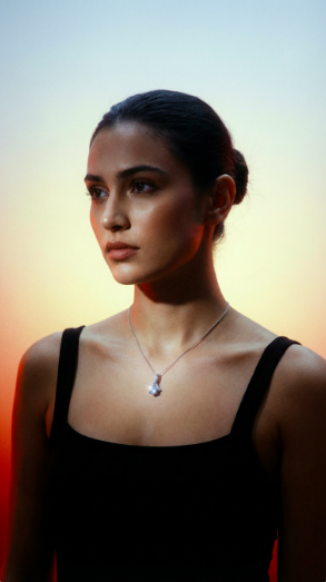 Woman wearing the Alluring Beauty pendant necklace against a soft gradient background