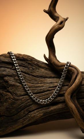 Silver Cuban link chain necklace displayed on natural wood for men