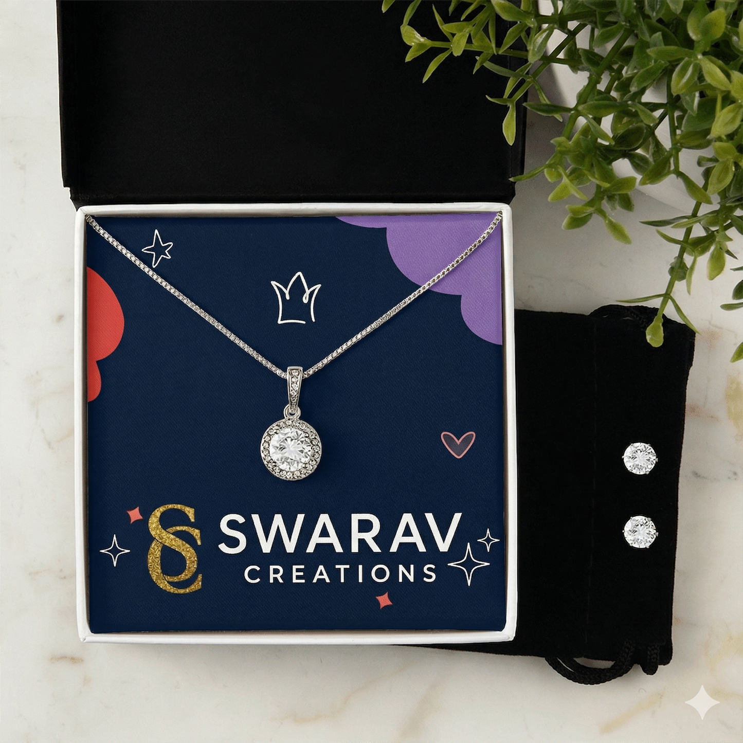 Silver necklace with a pendant in a Swarav Creations box on a dark background
