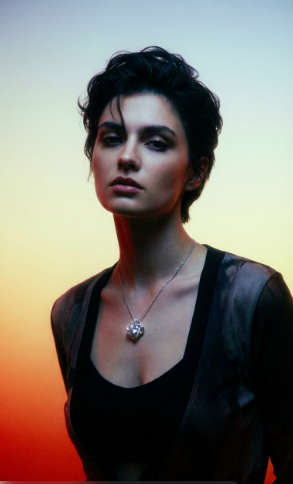 Woman wearing an Eternal Love pendant necklace against a gradient background