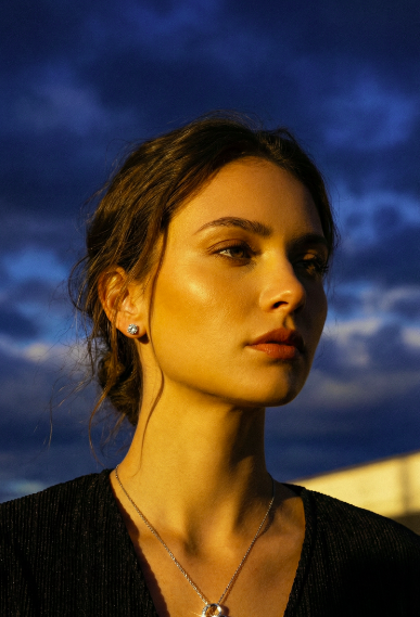 Woman wearing Forever love necklace and earring in a blue sky background