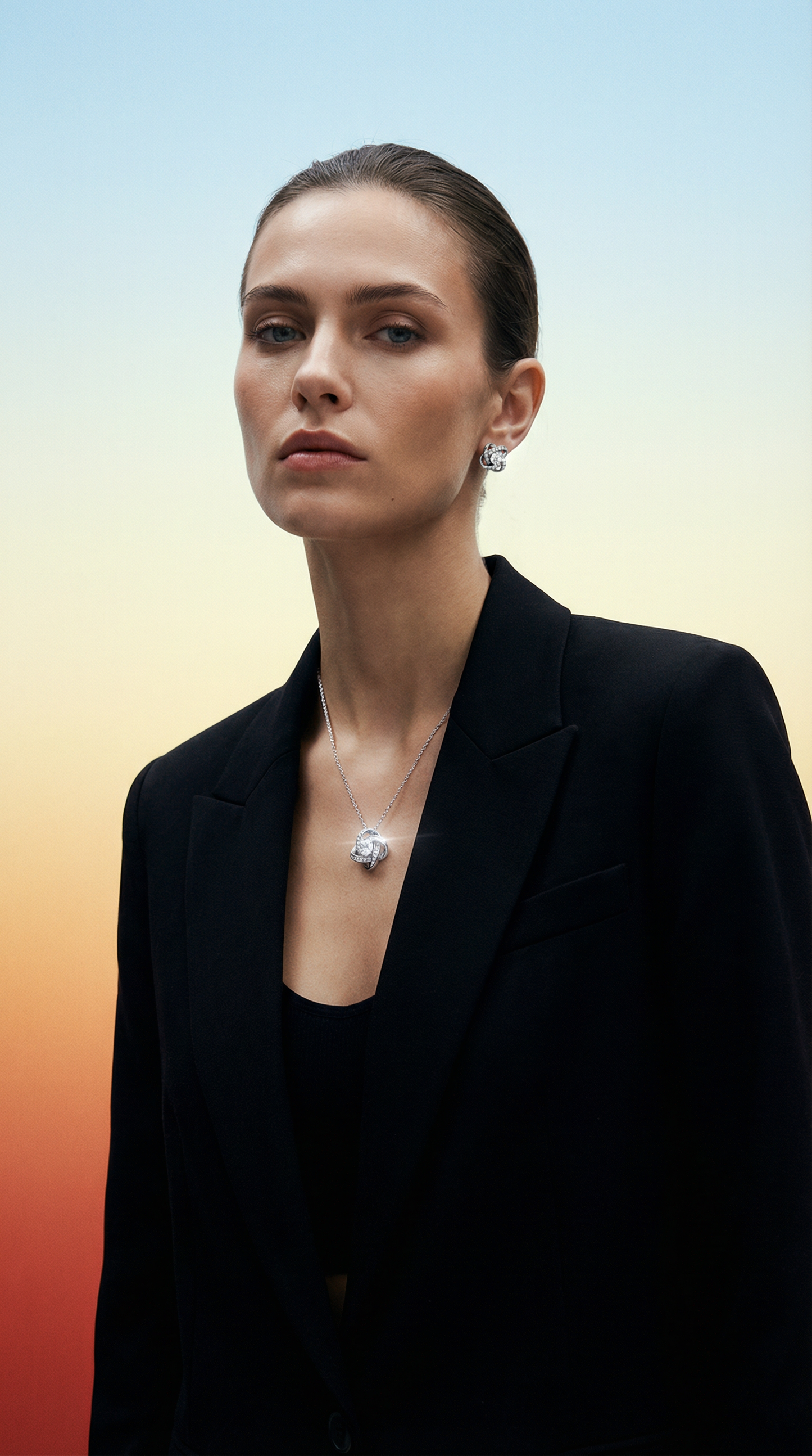 Woman wearing a black blazer with a necklace against a gradient wearing Love Knot Necklace and Earring Set by Swarav Creationsbackground