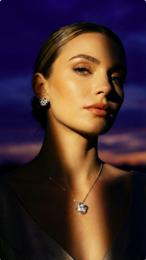 Woman wearing a Love Knot necklace and matching earring set against a dark background
