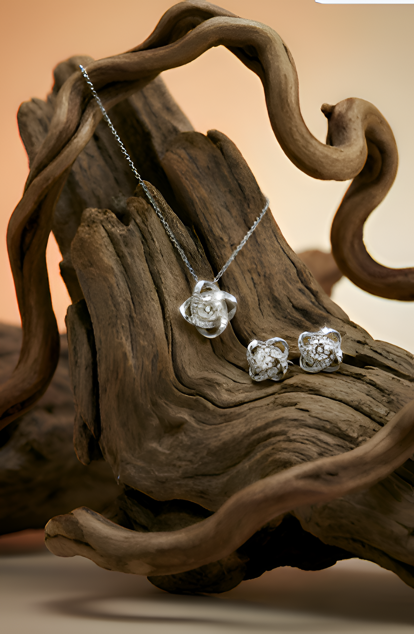 Love Knot necklace and matching earring set displayed on natural driftwood background