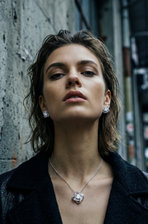 Woman wearing a Love Knot necklace and matching earring set in an urban setting