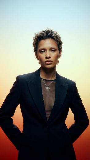Model wearing an Aries zodiac pendant necklace against a gradient background