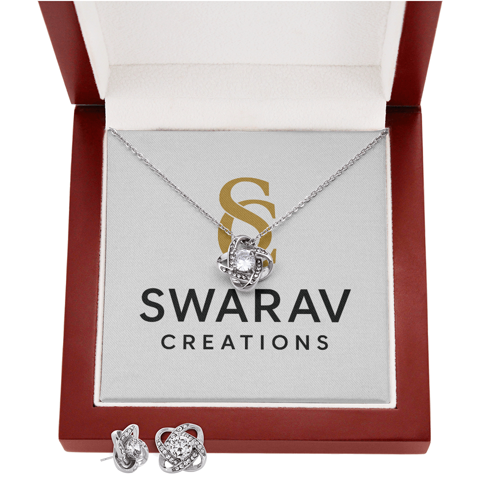 Love knot necklace and earring set in 14k white gold with cubic zirconia, displayed in a red luxury gift box
